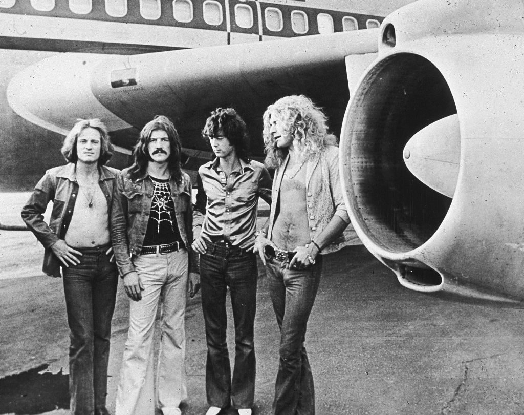 Led Zeppelin, (left - right): John Paul Jones, John Bonham (1948 - 1980), Jimmy Page and Robert Plant, pose in front of an their private airliner The Starship, 1973.