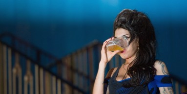 Amy Winehouse drinks a pint of lager as she watches The Libertines perform live at The Forum