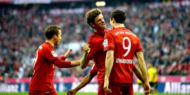 Robert Lewandowski (R) of Muenchen celebrates with Thomas Mueller (C) of Muenchen and Mario Goetze of Muenchen after scoring his team's third goal during the Bundesliga match between FC Bayern Muenchen and Borussia Dortmund at Allianz Arena on October 4, 