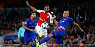 Theo Walcott of Arsenal is challenged by Esteban Cambiasso of Olympiacos during the UEFA Champions League Group F match between Arsenal FC and Olympiacos FC at the Emirates Stadium on September 29, 2015 in London, United Kingdom. 