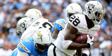 Latavius Murray #28 of the Oakland Raiders carries the ball as he is chased by Corey Liuget #94 of the San Diego Chargers during the first quarter at Qualcomm Stadium on October 25, 2015 in San Diego, California. 