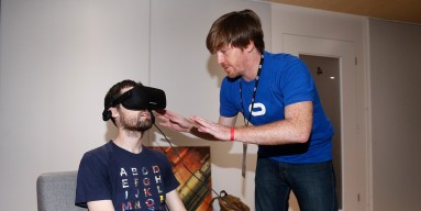 Oculus emplyoee Patrick Hercamp (R) helps set up the virtual reality head-mounted display Oculus Rift CV1 on John Peters (L) at the Annual Gaming Industry Conference E3 at the Los Angeles Convention Center on June 16, 2015 in Los Angeles, California. The 
