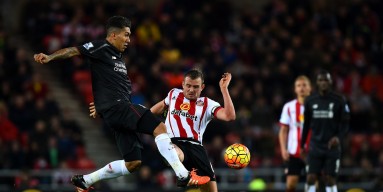 Roberto Firmino of Liverpool passes the ball under pressure from Lee Cattermole of Sunderland during the Barclays Premier League match between Sunderland and Liverpool at Stadium of Light on December 30, 2015 in Sunderland, England. 