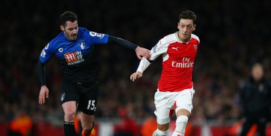 Mesut Ozil of Arsenal and Adam Smith of Bournemouth compete for the ball during the Barclays Premier League match between Arsenal and A.F.C. Bournemouth at Emirates Stadium on December 28, 2015 in London, England. 