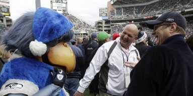 Paul Allen (right) interacts with the mascot of the Seattle Seahawks