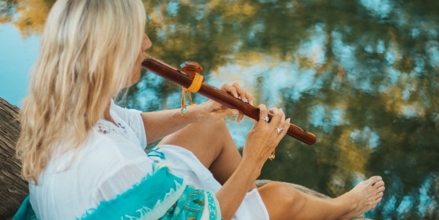 woman in white and teal dress playing flute