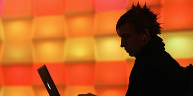 A participant sits with a laptop computer as he attends the annual Chaos Communication Congress of the Chaos Computer Club at the Berlin Congress Center